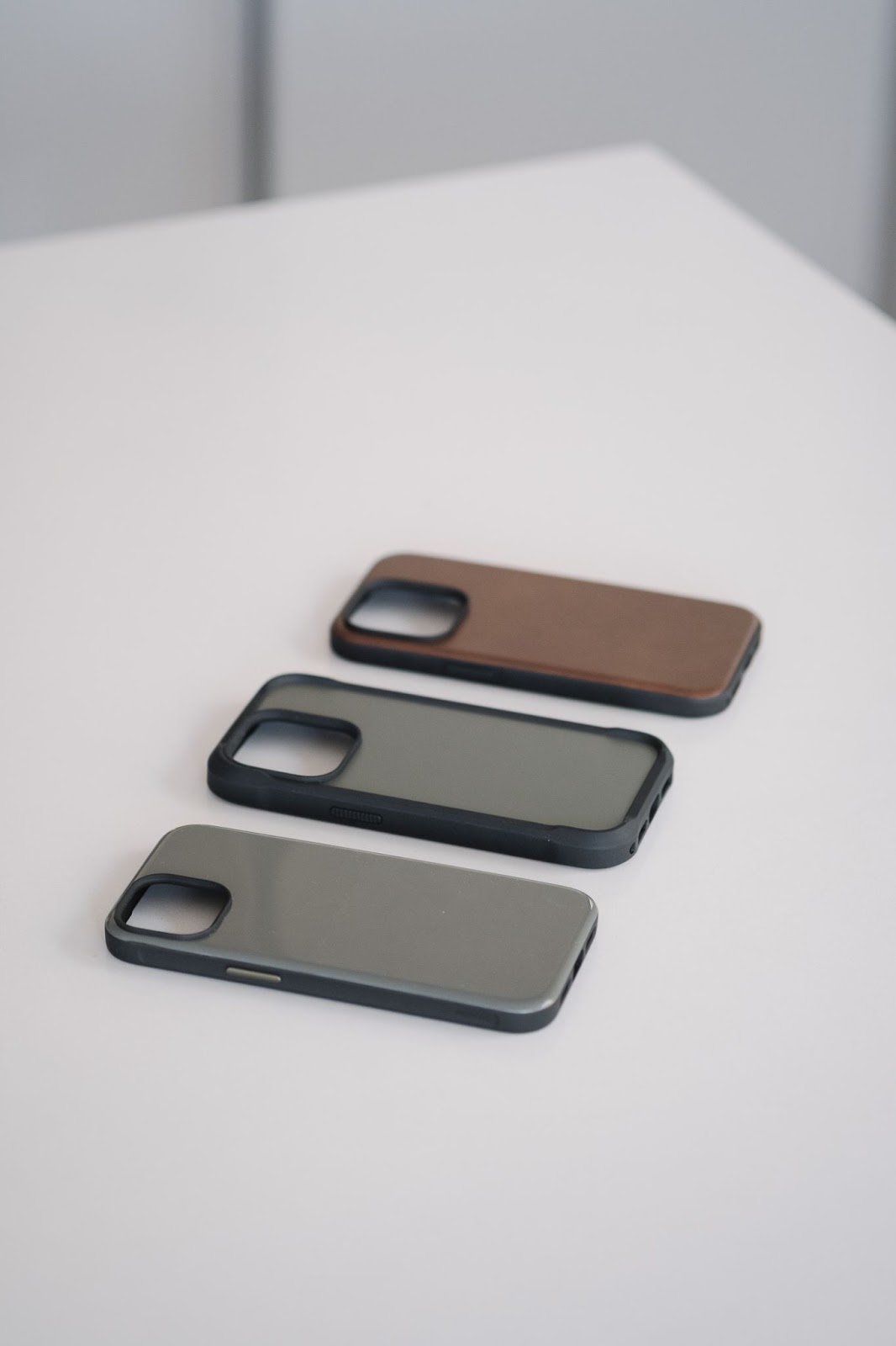 Three iphone cases on a white table