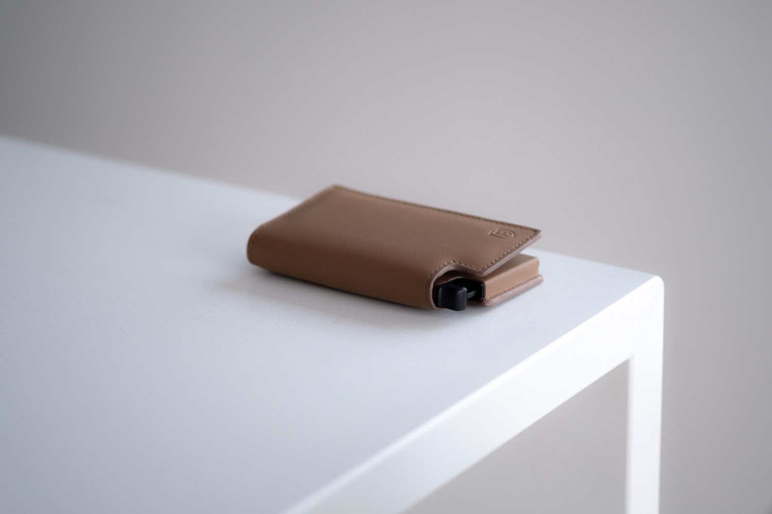 tan colored ekster wallet on white counter