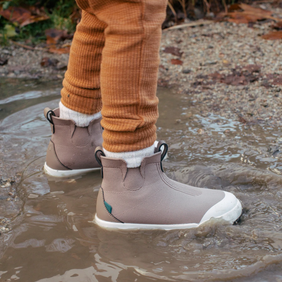 child standing in puddle wearing vessi shoes