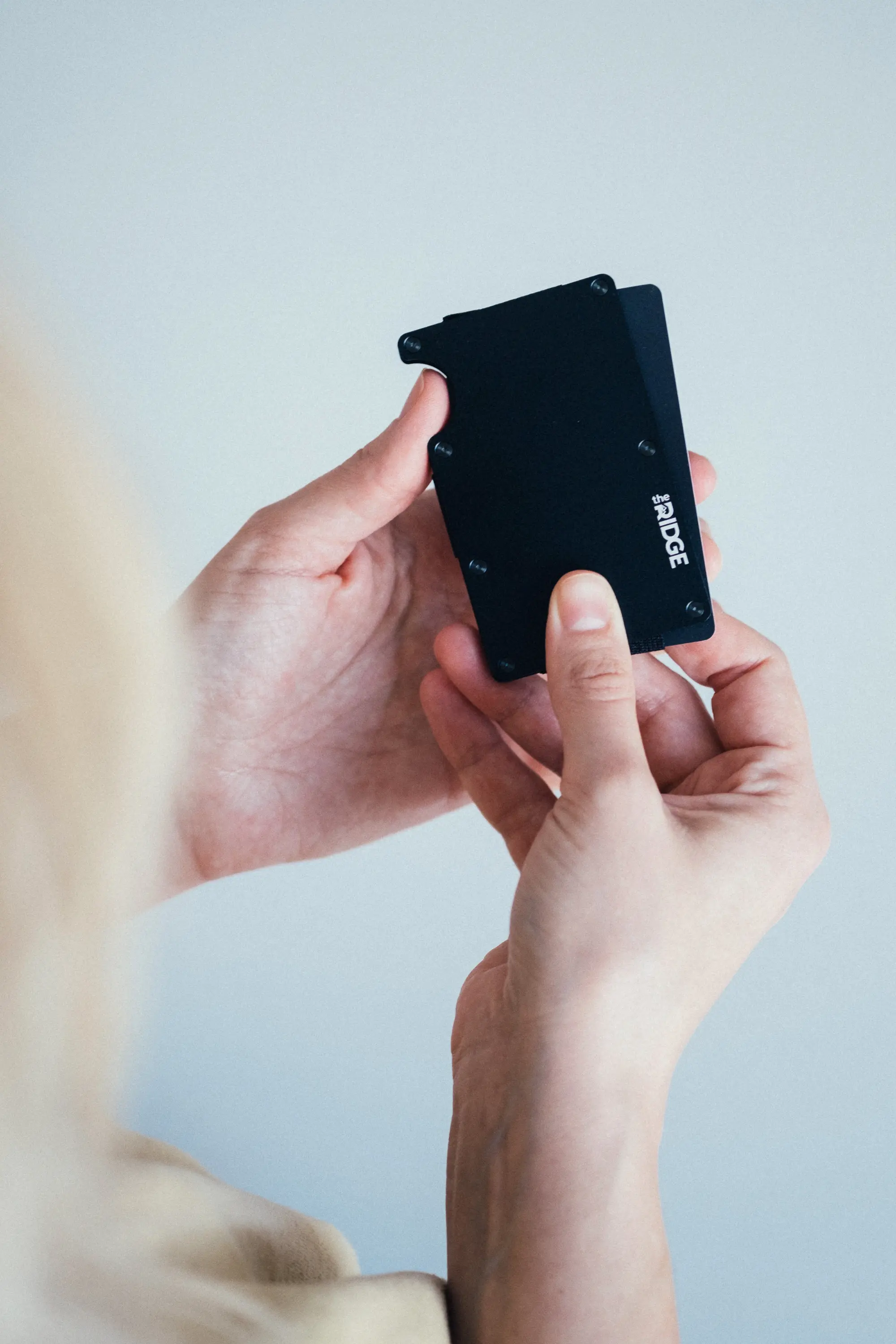 Woman pushing cards out of ridge wallet