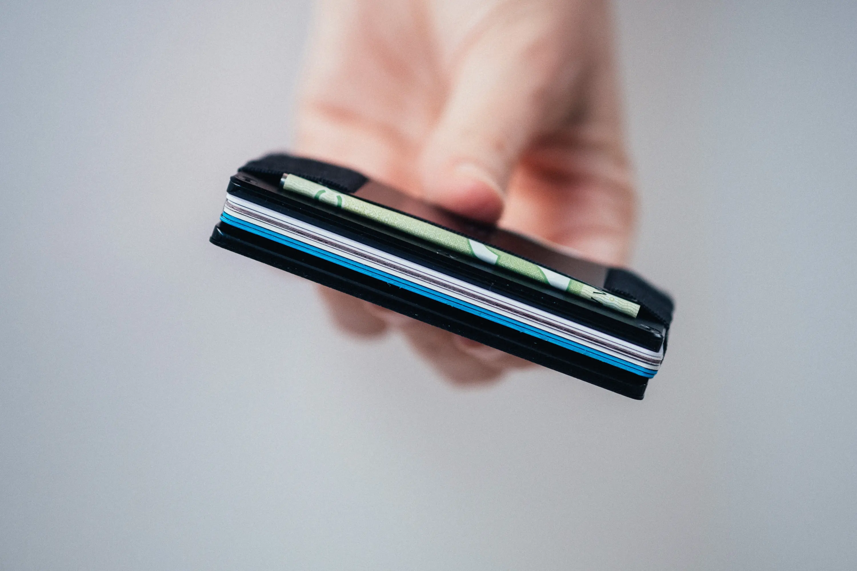 Woman holding ridge wallet showing 6 cards inside
