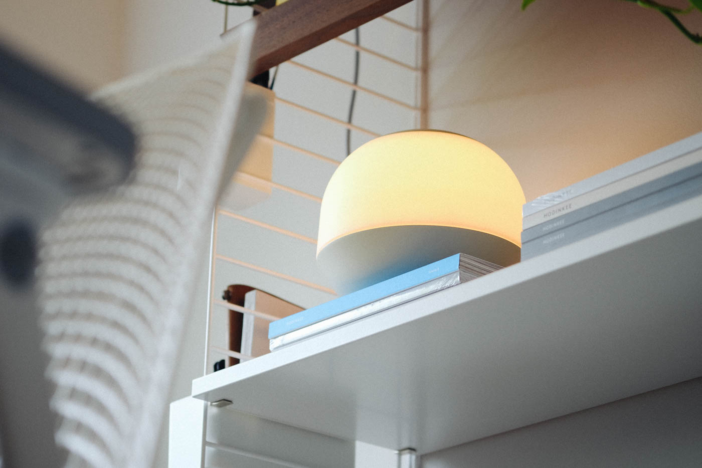 Light sitting on some books in a shelf in an office